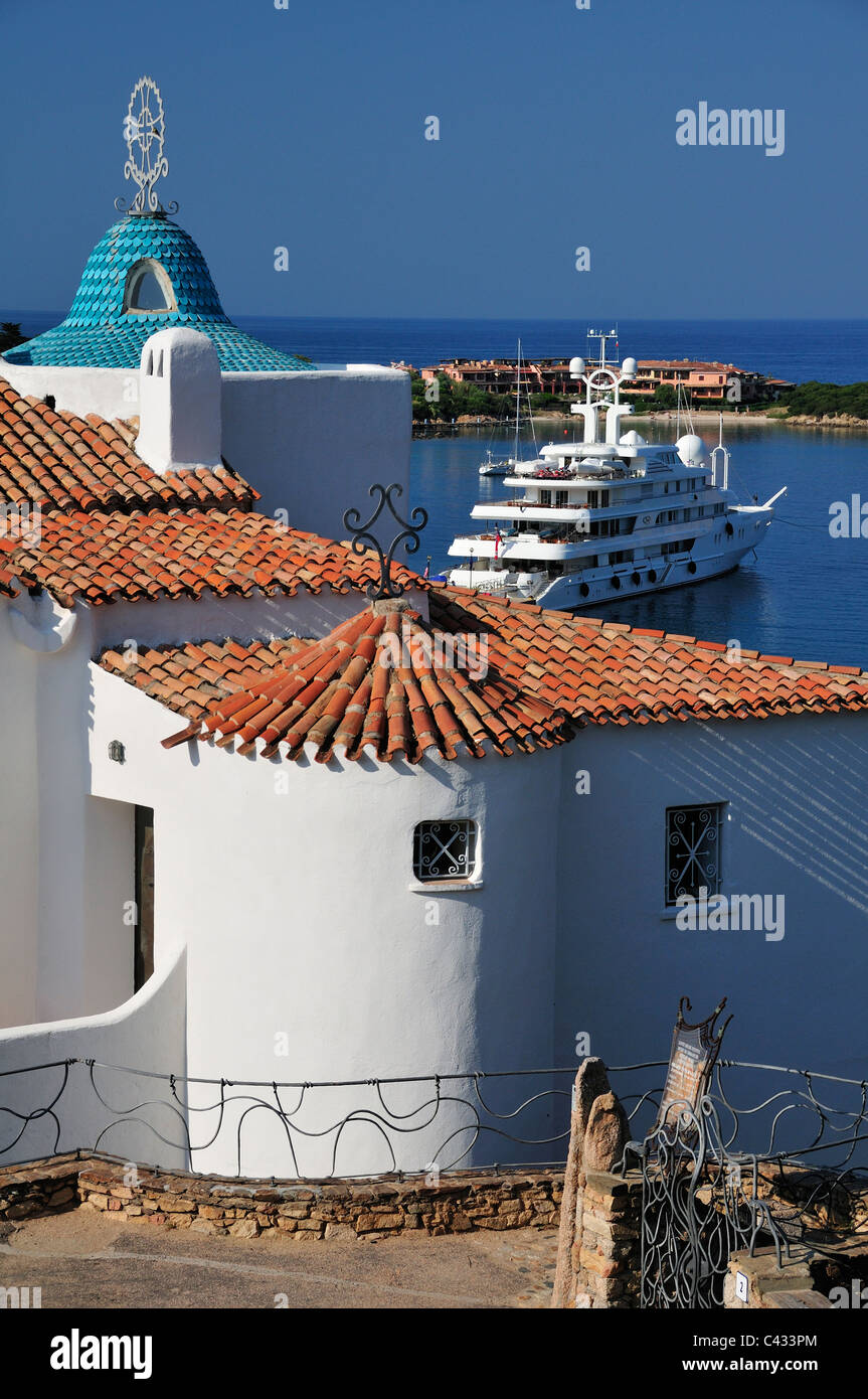 Der Hafen von Porto Cervo, Costa Smeralda, mit einem Teil der Stella Maris Kirche Chiesa im Vordergrund, Sardinien, Italien Stockfoto