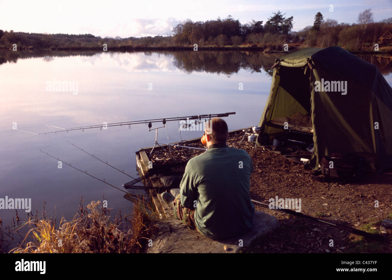 Angler, genießen eine Tasse Kaffee saß See wacht über Ruten in Stafford Moor Fischerei. Stockfoto