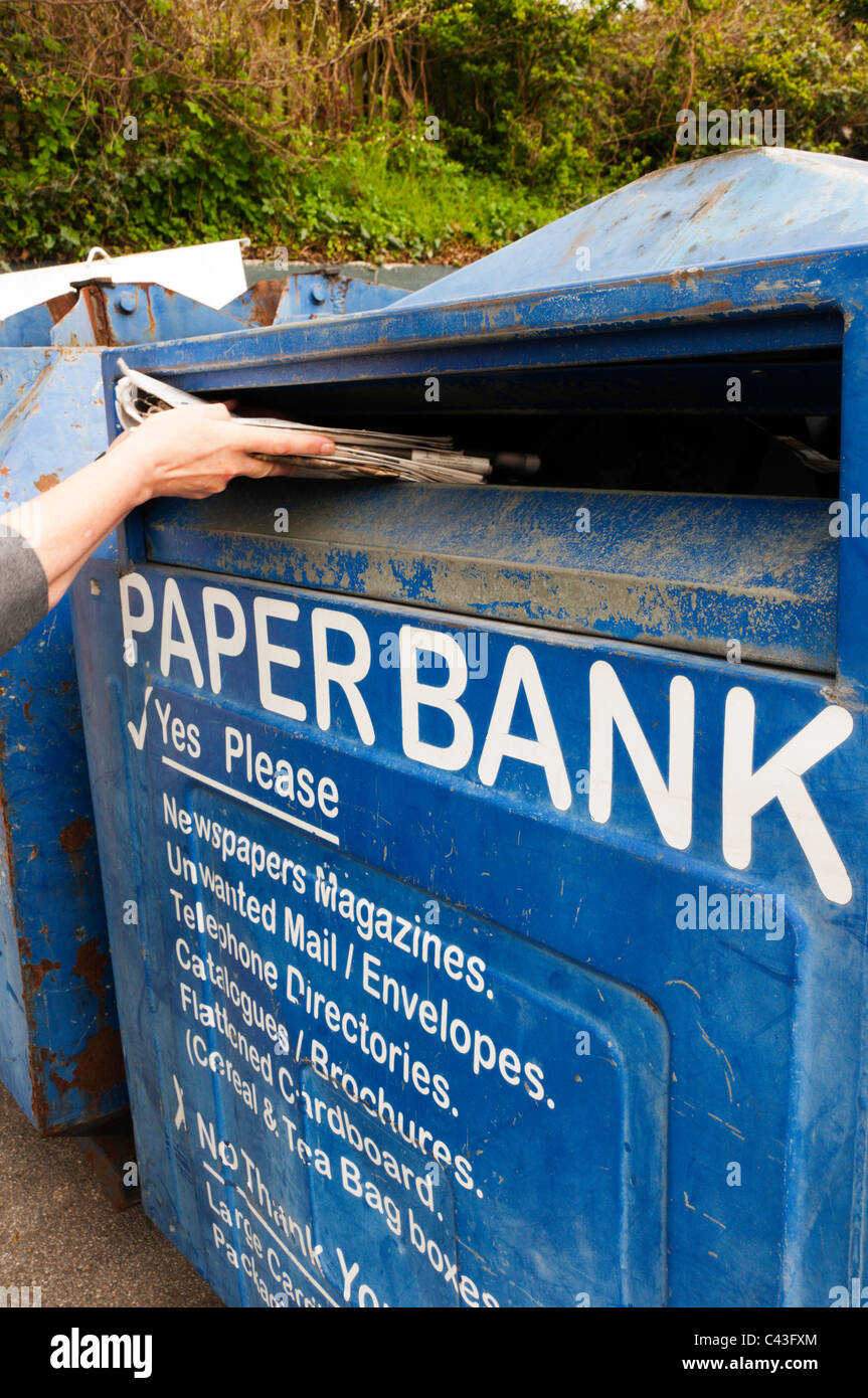 Eine Frau, die recycling-Zeitungen in einer großen bank Stockfoto