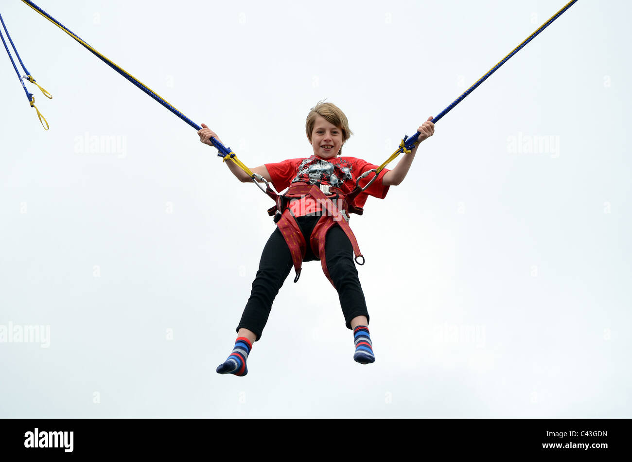 ein kleiner Junge auf einem Bungee-Trampolin Stockfoto