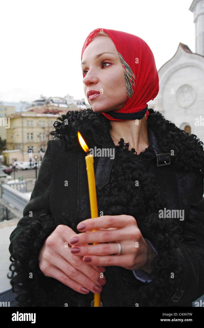 Das Mädchen der Christ mit einer Kerze gegen einen Tempel, Moskau, Russland Stockfoto