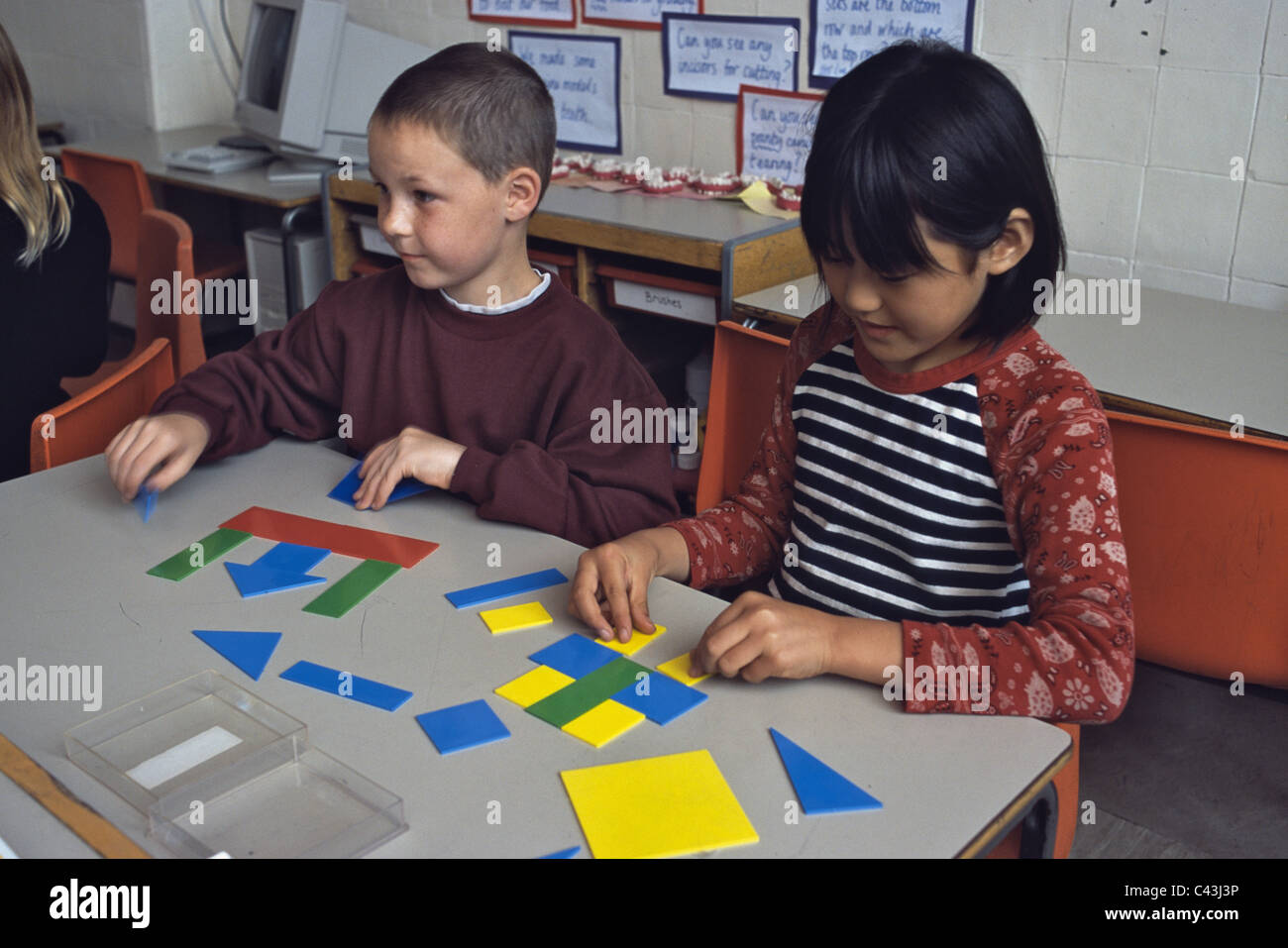 Kinder im Grundschulalter arbeiten mit farbigen Farbformen Stockfoto