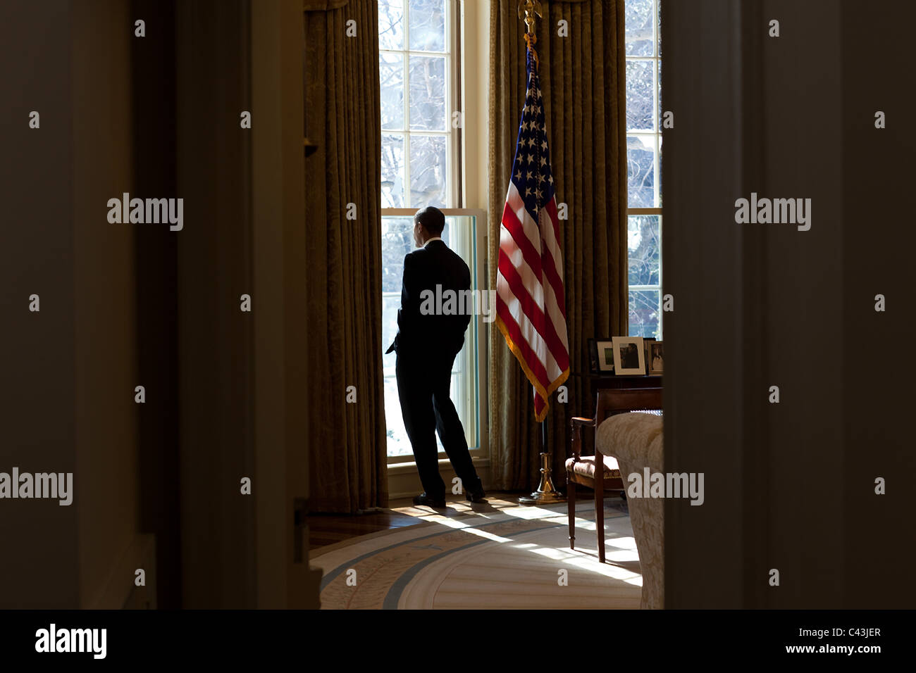 Präsident Barack Obama schaut aus dem Fenster des Oval Office Stockfoto