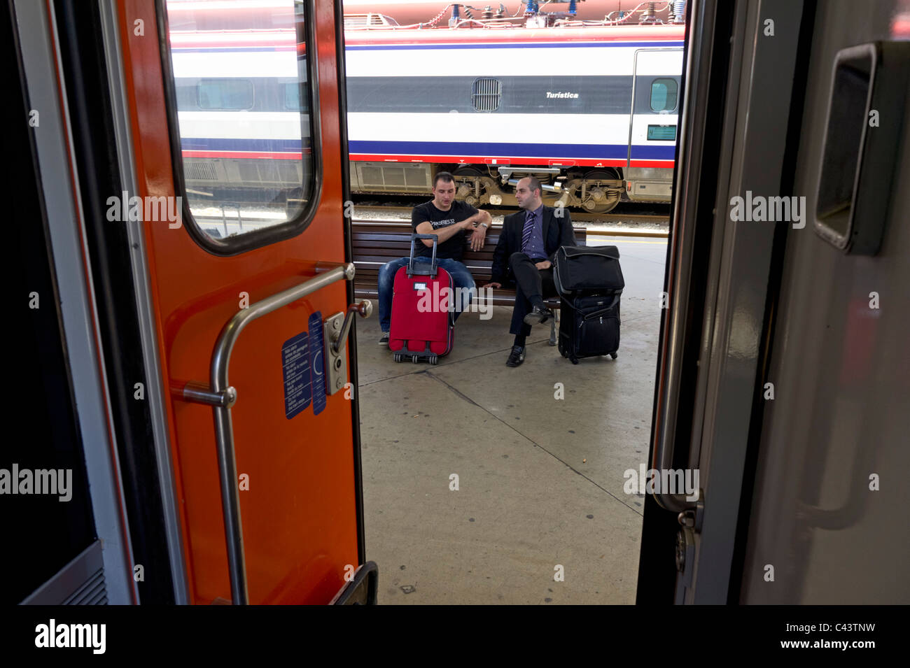 Zwei Passagiere warten auf die Ankunft ihres Zuges Stockfoto