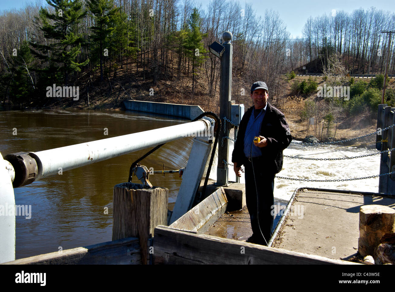 Techniker Anhebung Rost, Schmutz Falle bei kleinen privaten Riviere du Loup Power dam Wasserzulauf prüfen Stockfoto