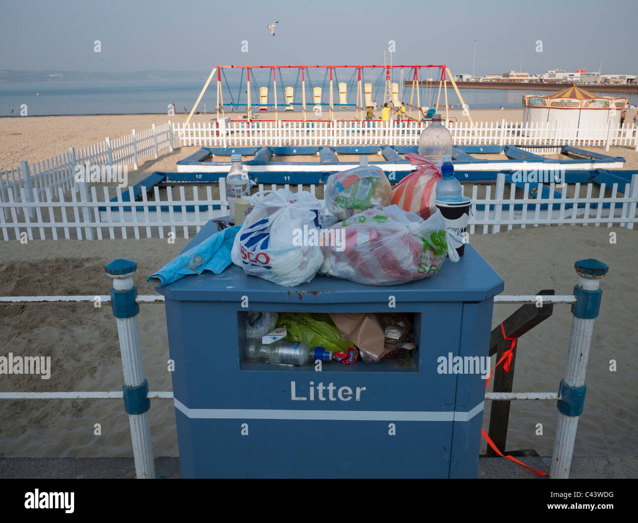 Ein voller volle Mülleimer an der Strandpromenade am Ende des Tages in Weymouth, Dorset, England Stockfoto