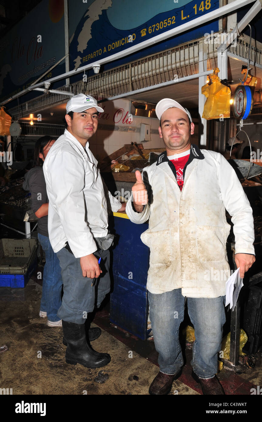 Zwei weiße insgesamt schwarze Stiefel Fischhändler stand lächelnd posiert vor Fisch-Stall, Mercado Central, Centro, Santiago, Chile Stockfoto