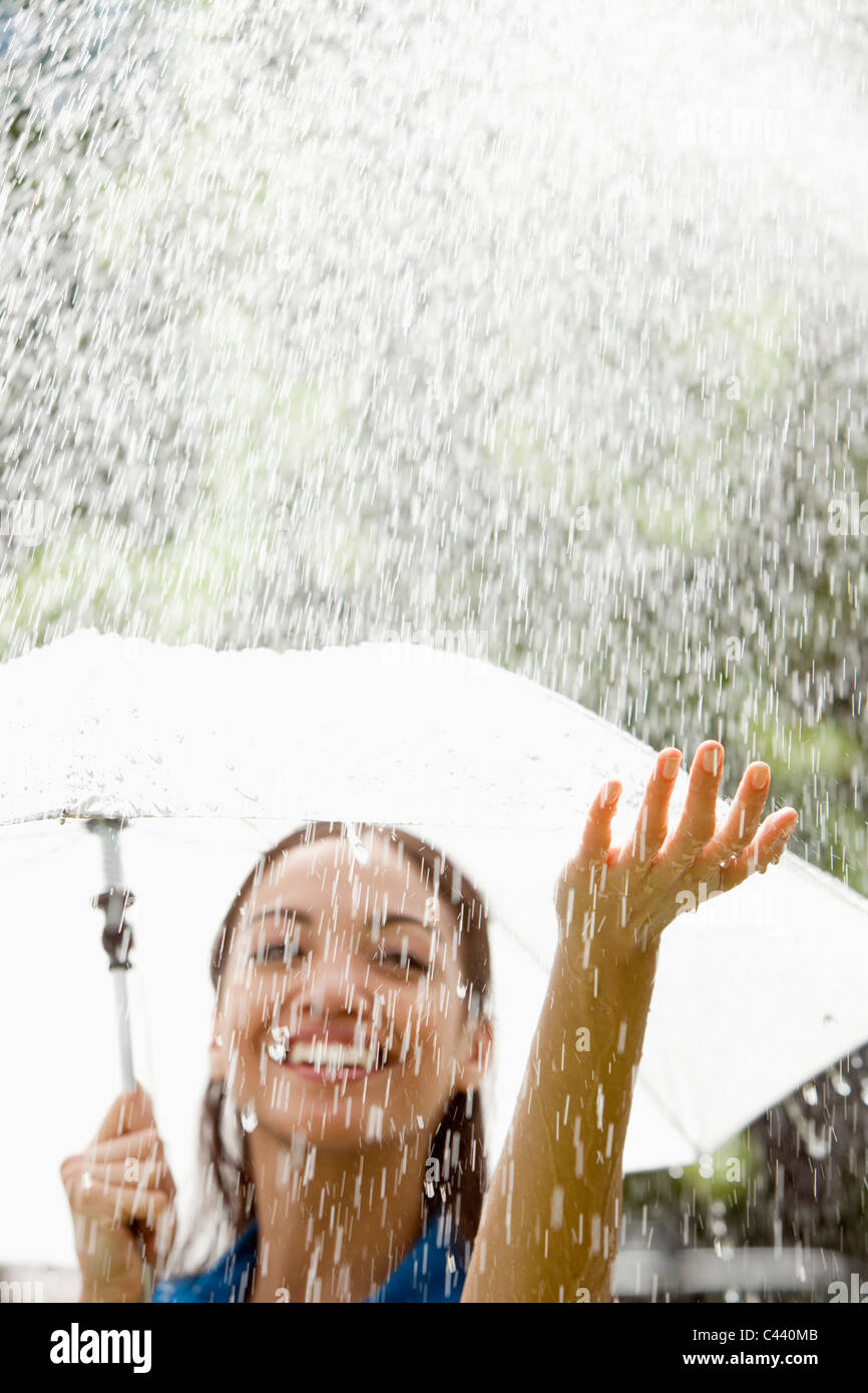 Schöne spanische Frau hält Regenschirm draußen im Regen Stockfoto
