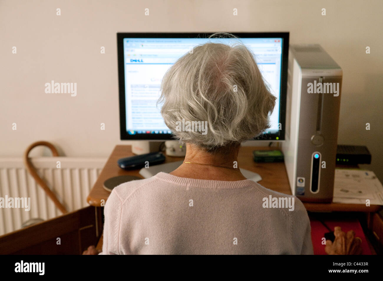 Ein älterer Silber Surfer, die mit ihrem Computer zu Hause Zugriff auf das Internet im Vereinigten Königreich Stockfoto