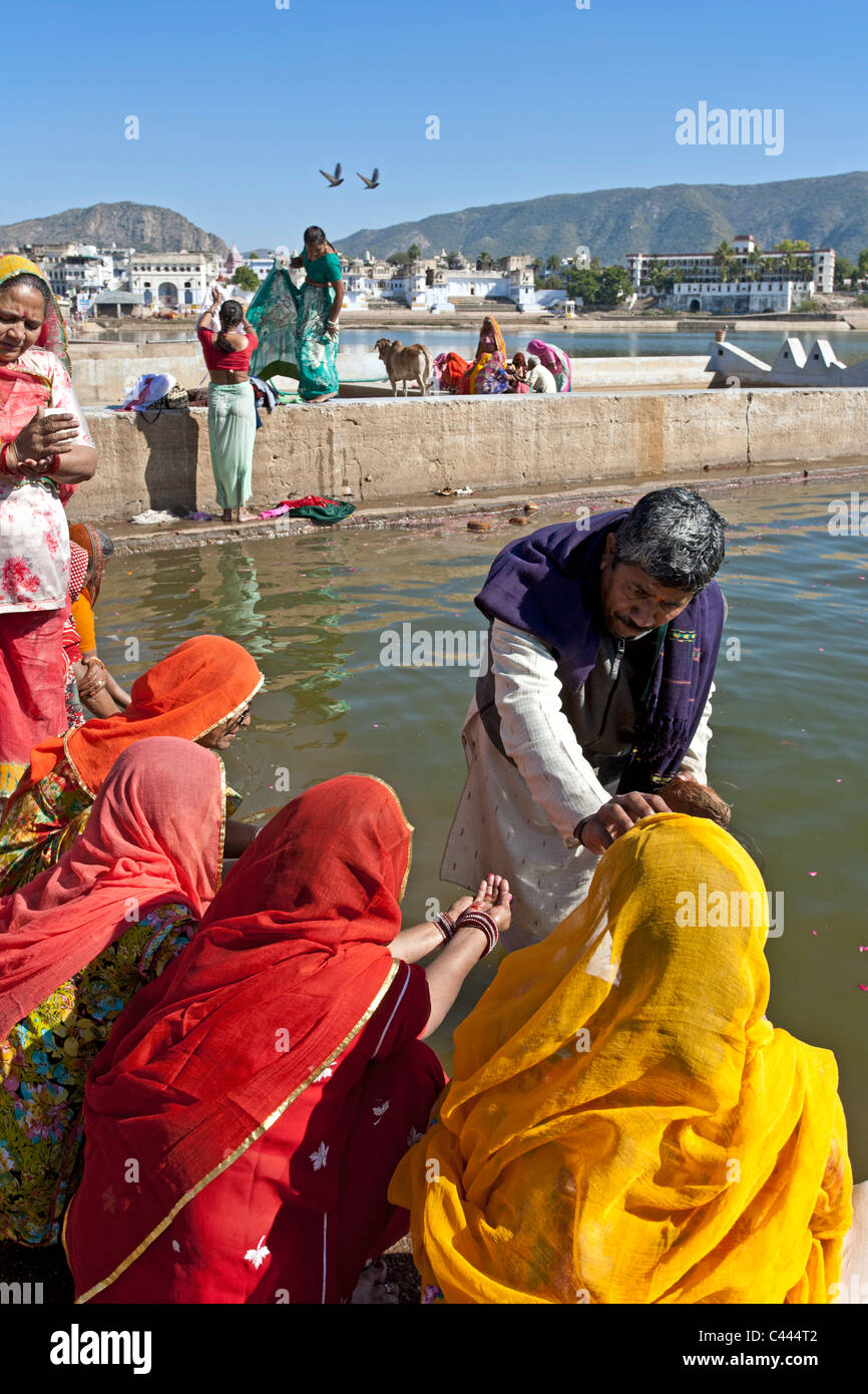 Indische Frauen und Brahmanen eine traditionelle Darbringung (Puja). Pushkar-See. Rajasthan. Indien Stockfoto
