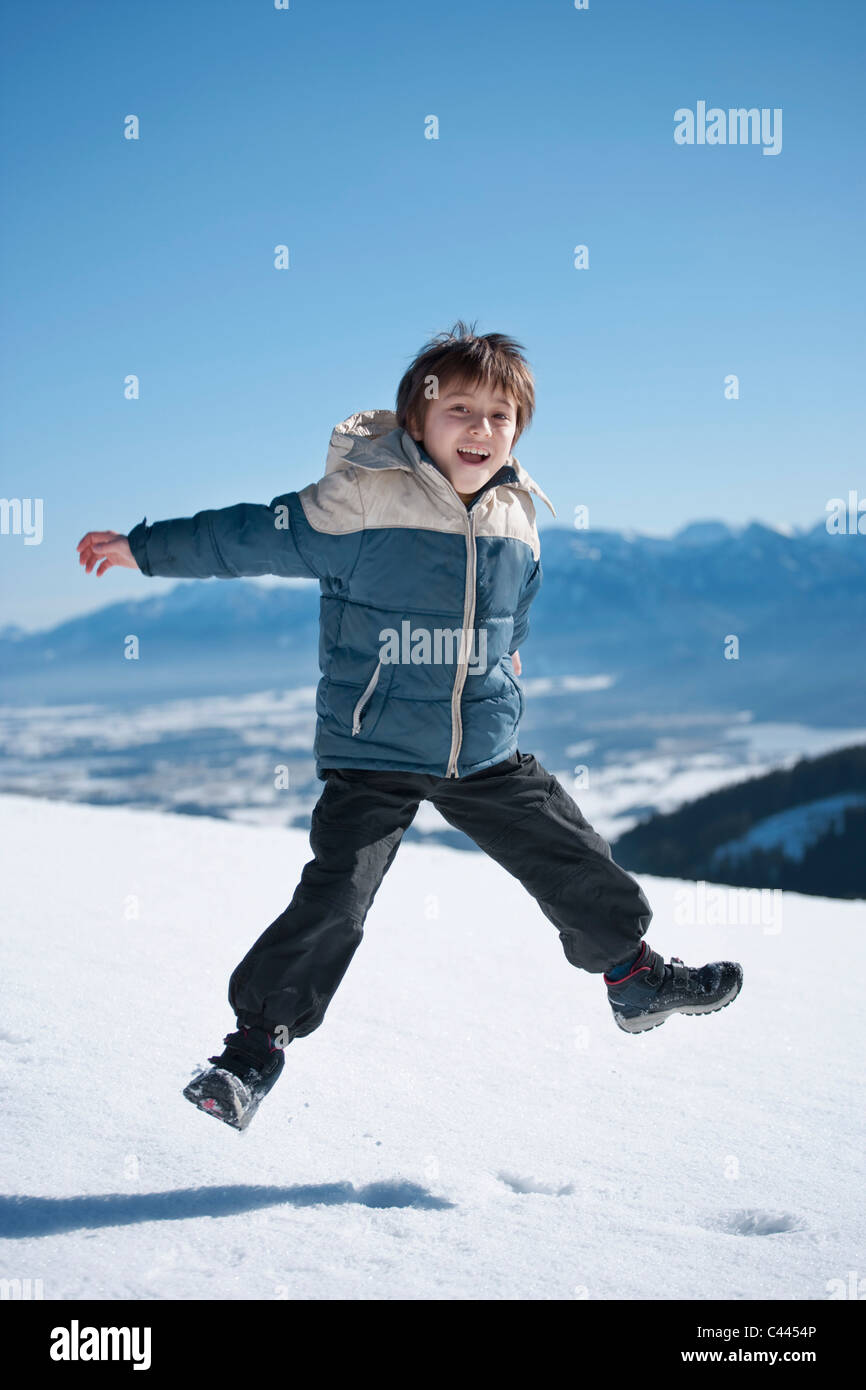 Ein Junge auf einem verschneiten Berg springen Stockfoto