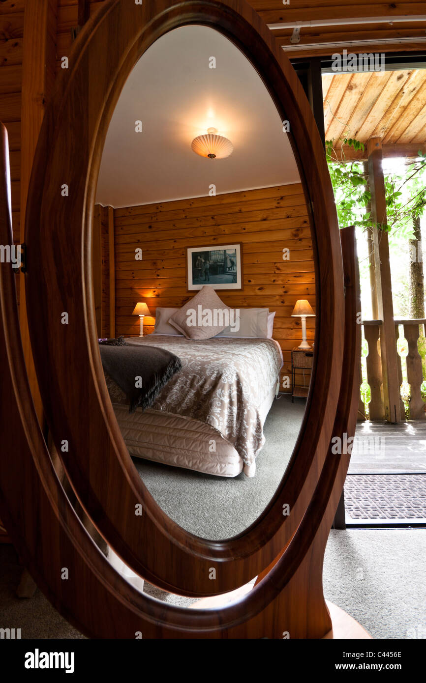 Schöne warme Schlafzimmer Innenraum Mountain Lodge in Spiegel reflektiert. Stockfoto