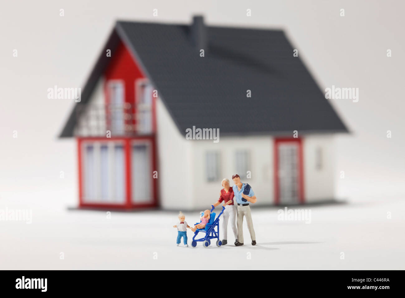 Eine junge Familie von Miniatur-Figuren vor einem Haus Stockfoto