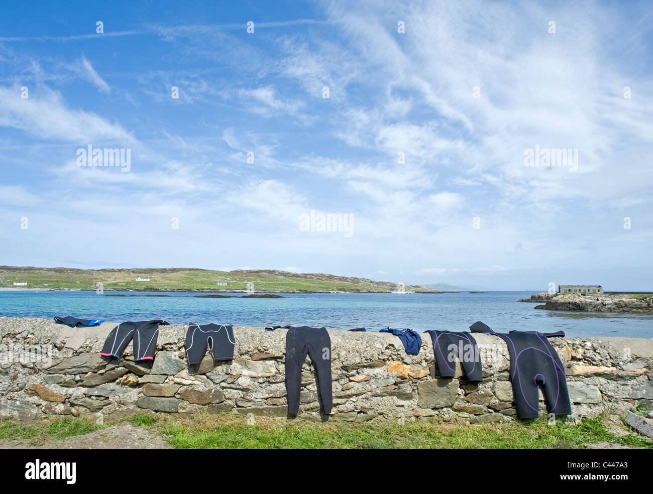 Nassen Badesachen trocknen an der Wand auf Inishbofin, County Galway, Irland. Stockfoto