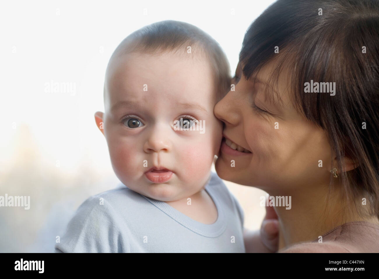 Eine Frau küssen ihr überrascht Baby boy Stockfoto