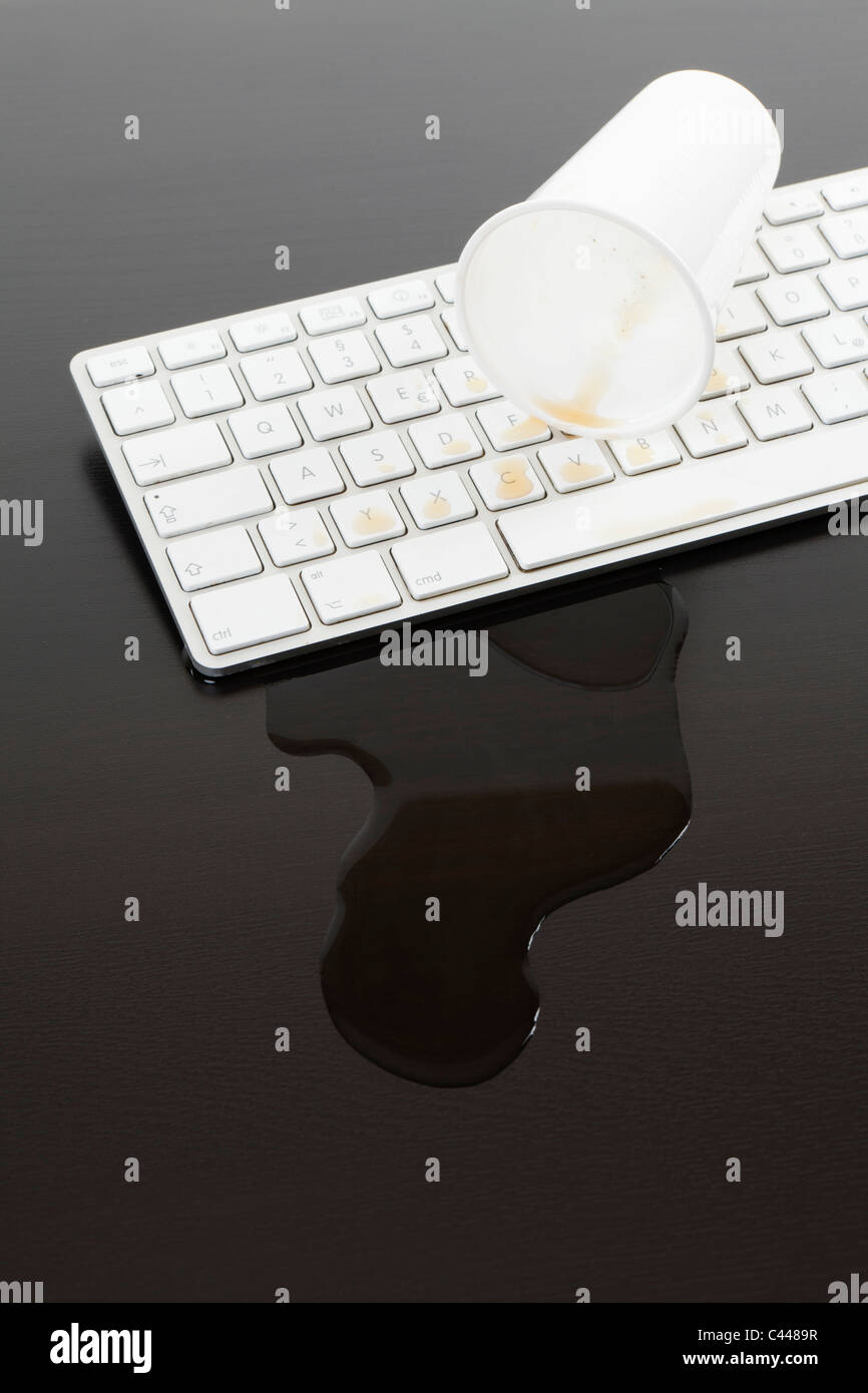 Eine Tasse Natron auf eine Computertastatur verschüttet Stockfoto