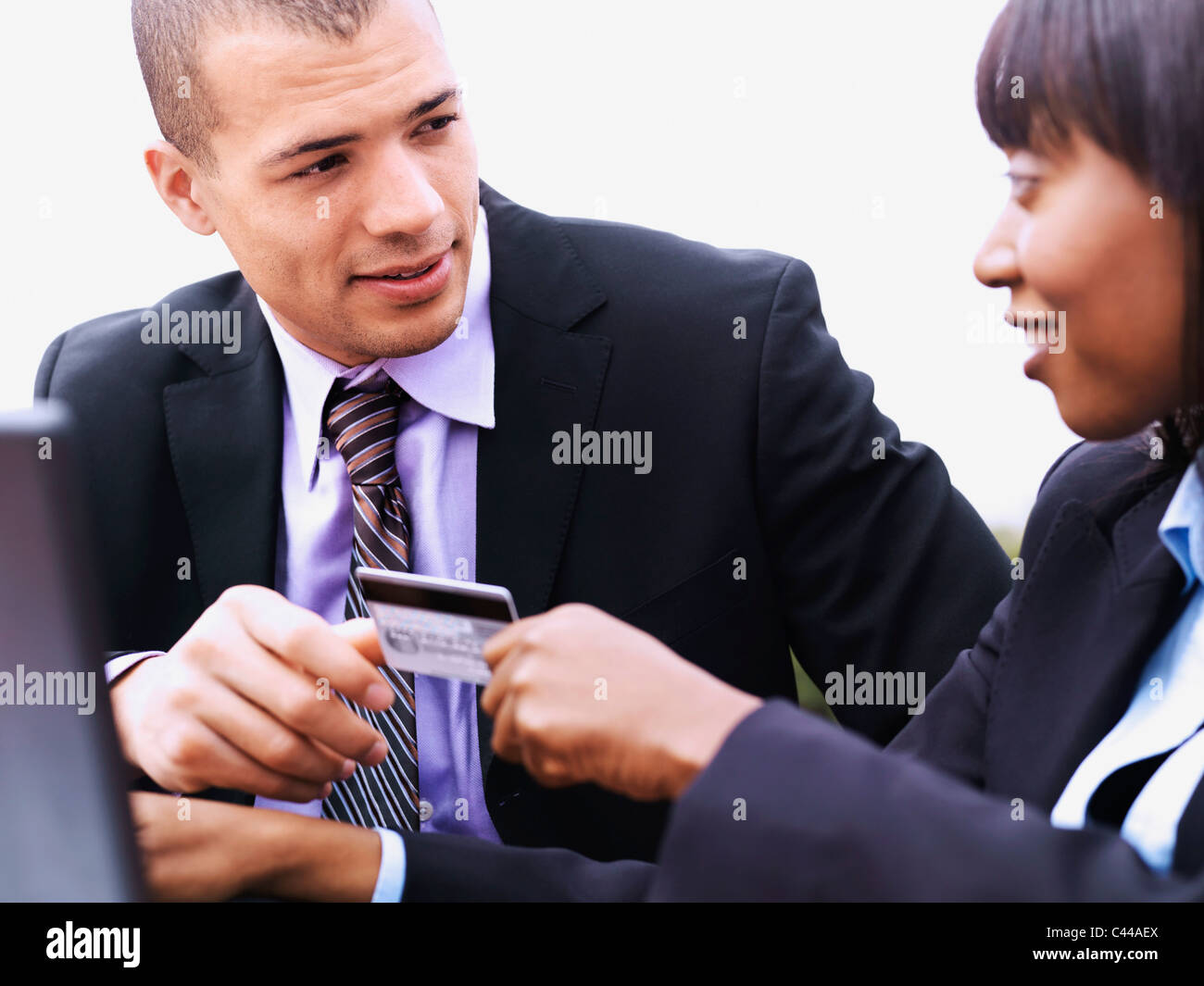 Eine Geschäftsfrau geben einem Geschäftsmann eine Kreditkarte Stockfoto