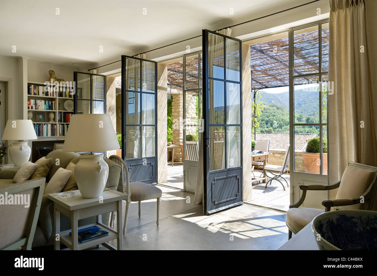 Geräumiges Wohnzimmer mit drei offenen französischen Fenster, Terrasse mit provenzalischen Ausblicke führen. Stockfoto