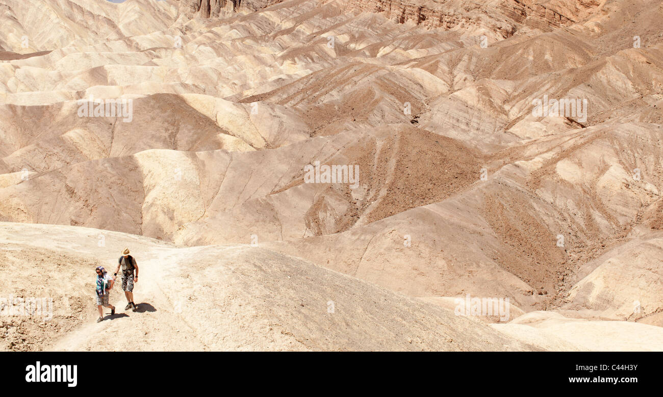 Death Valley Wanderer machen ihren Weg über Wellen des Felsens. Der Nationalpark ist ein beliebtes Ausflugsziel für Wanderer trotz der Hitze Stockfoto