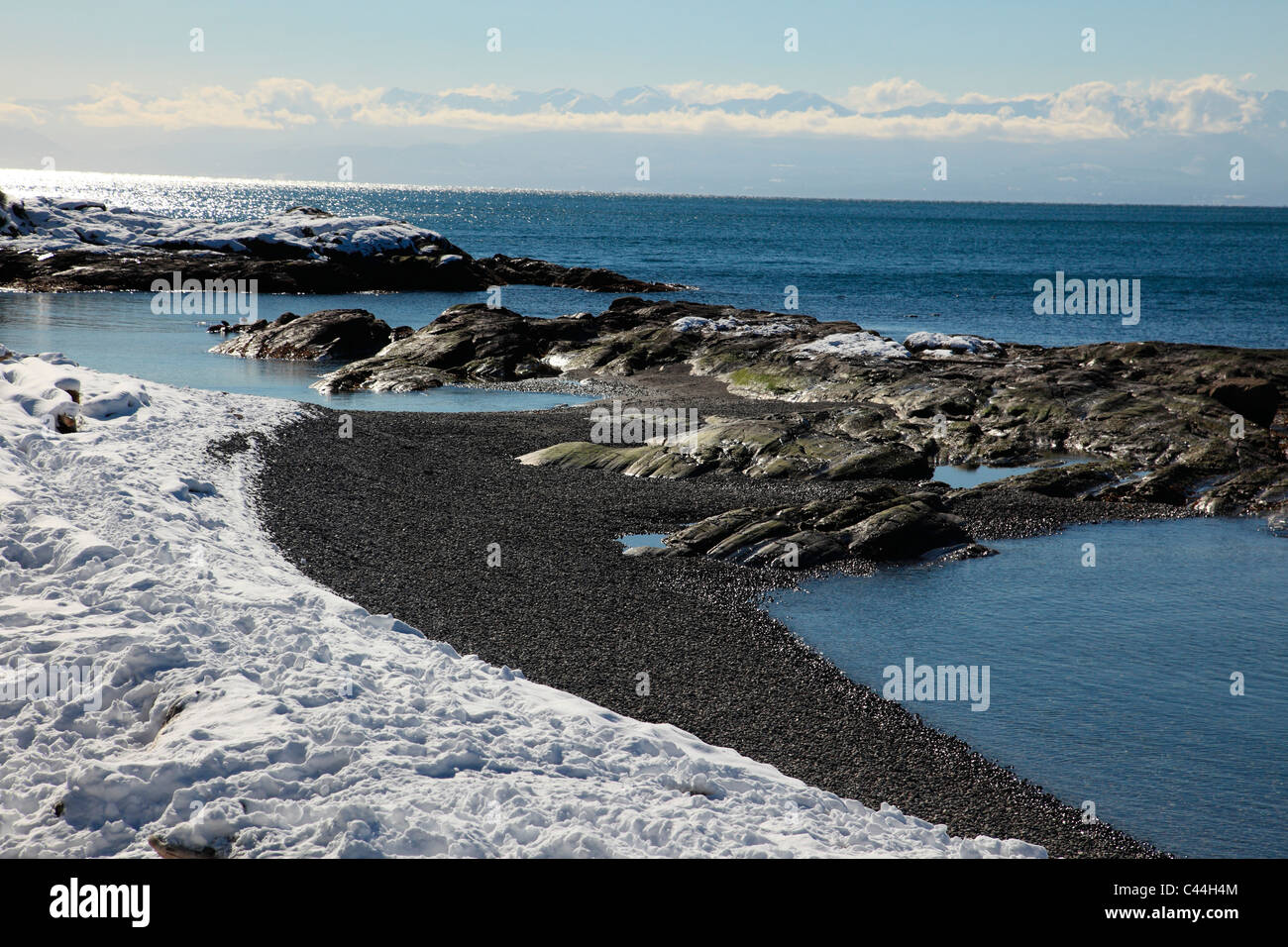 schneebedeckte felsigen Strand mit Blick auf den Ozean Stockfoto