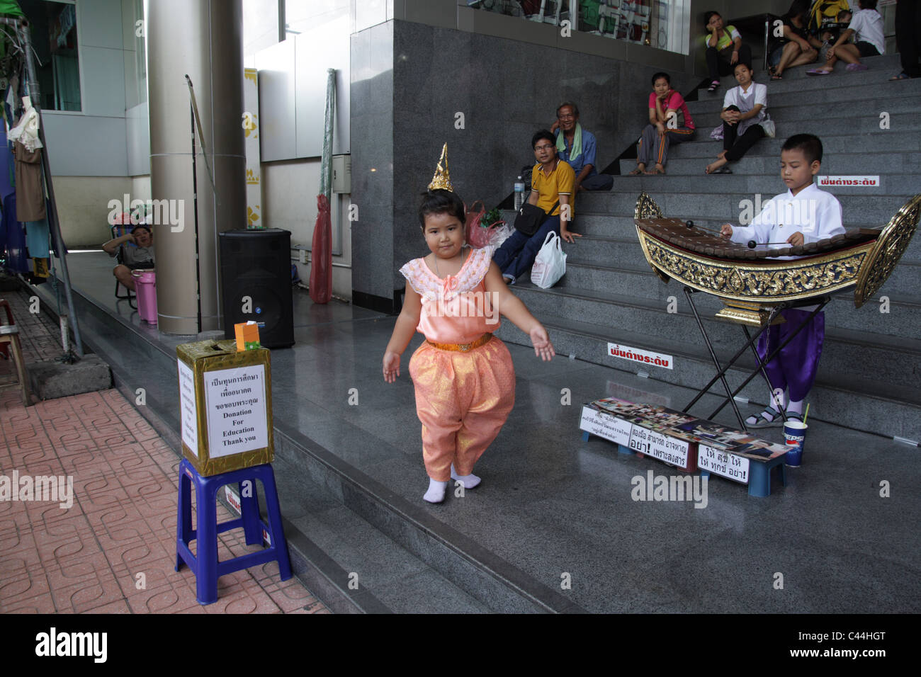 Thai Mädchen tanzen mit thailändischen Musiker am Chatuchak Weekend Market in Bangkok Stockfoto