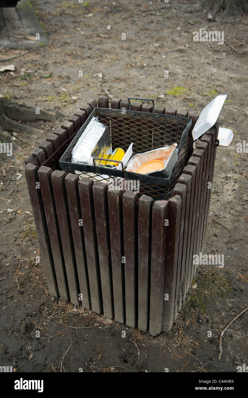 Ein Papierkorb, überfüllte mit Müll in einem öffentlichen Park. Stockfoto