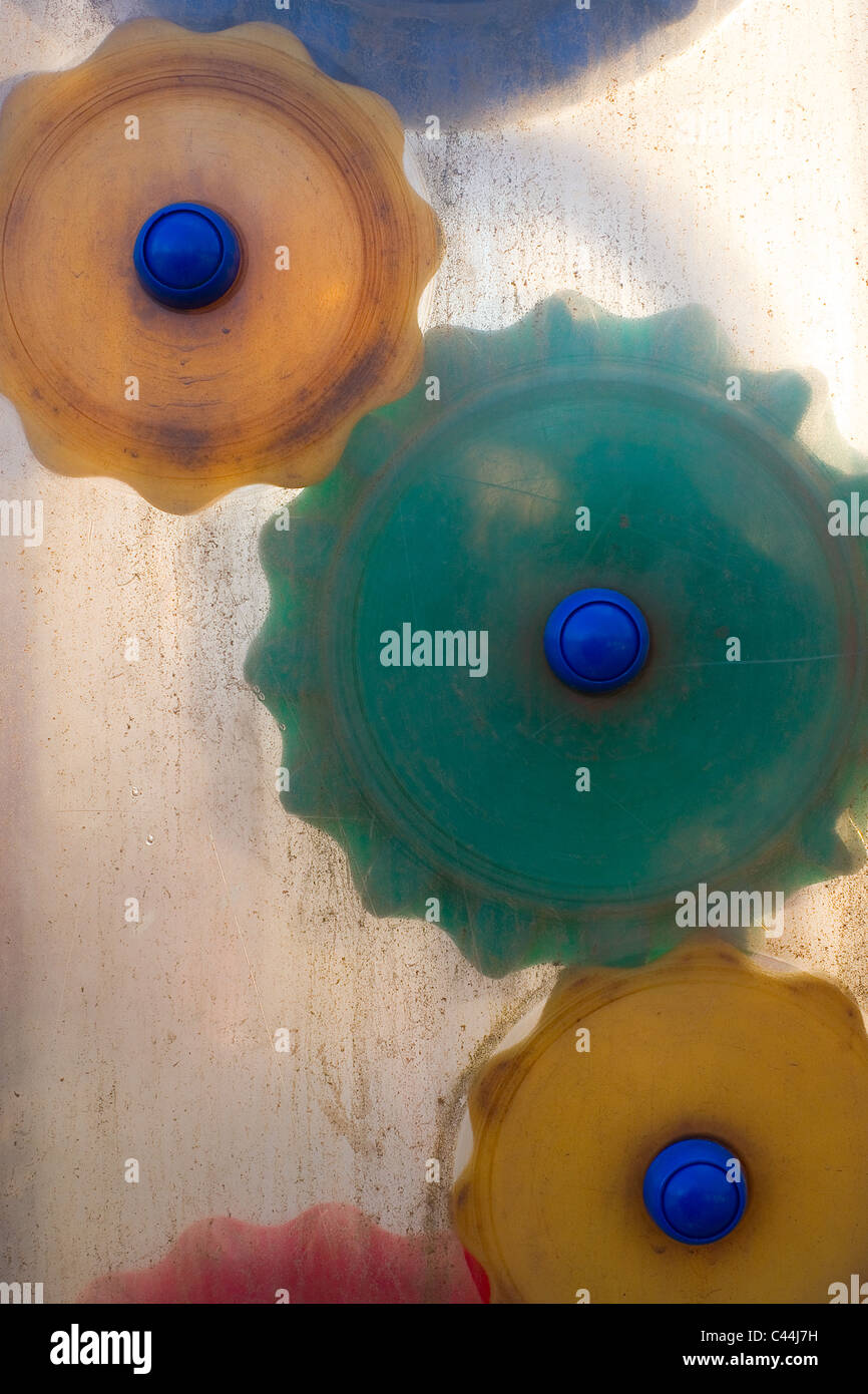 Drei Kunststoff-Zahnräder hinter einem Blatt schmutzig Plexiglas montiert. Stockfoto