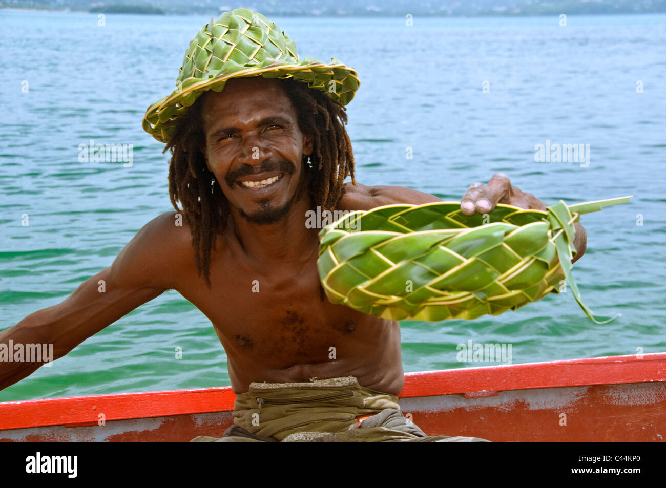 St. Lucian Mann verkaufen Palm Frond Produkten aus ein Boot, St. Lucia, Karibik, West Indies Stockfoto