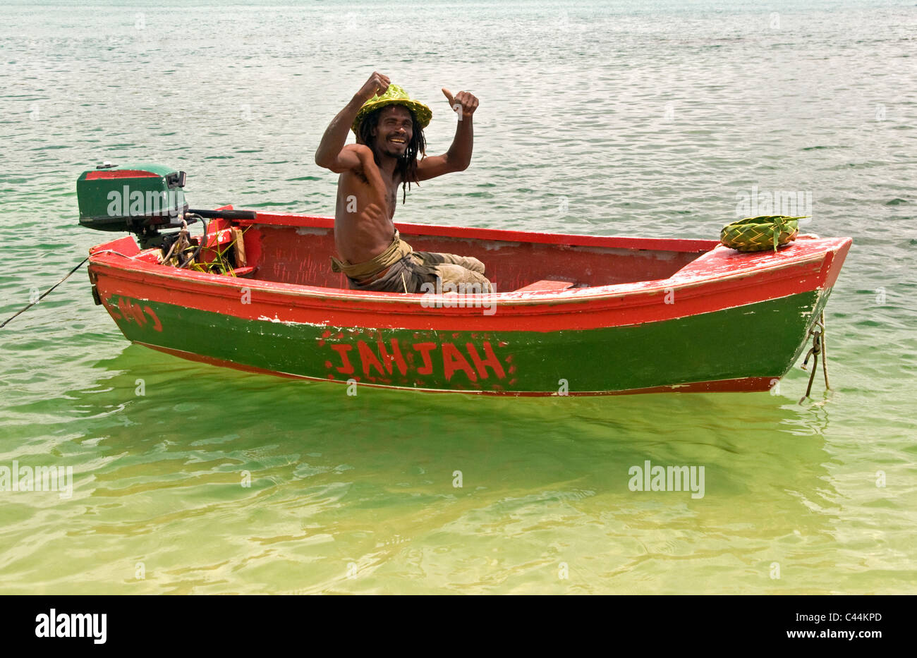 St. Lucian Mann mit Palm Frond-Produkte im roten Boot mit Daumen hoch, St. Lucia, Karibik, West Indies Stockfoto