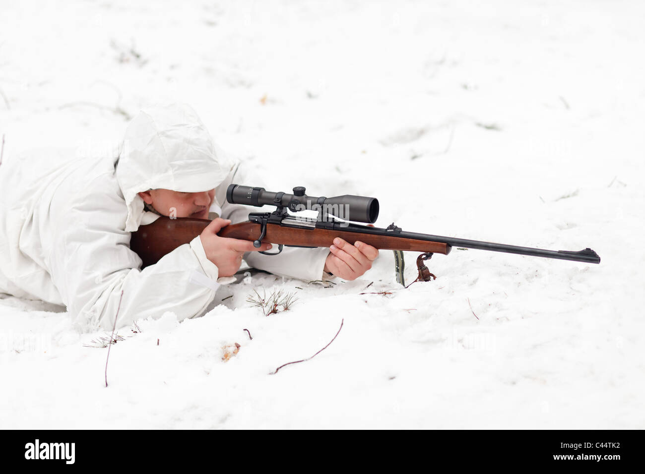 Scharfschützen in weiße Tarnung mit dem Ziel auf Schnee. Stockfoto