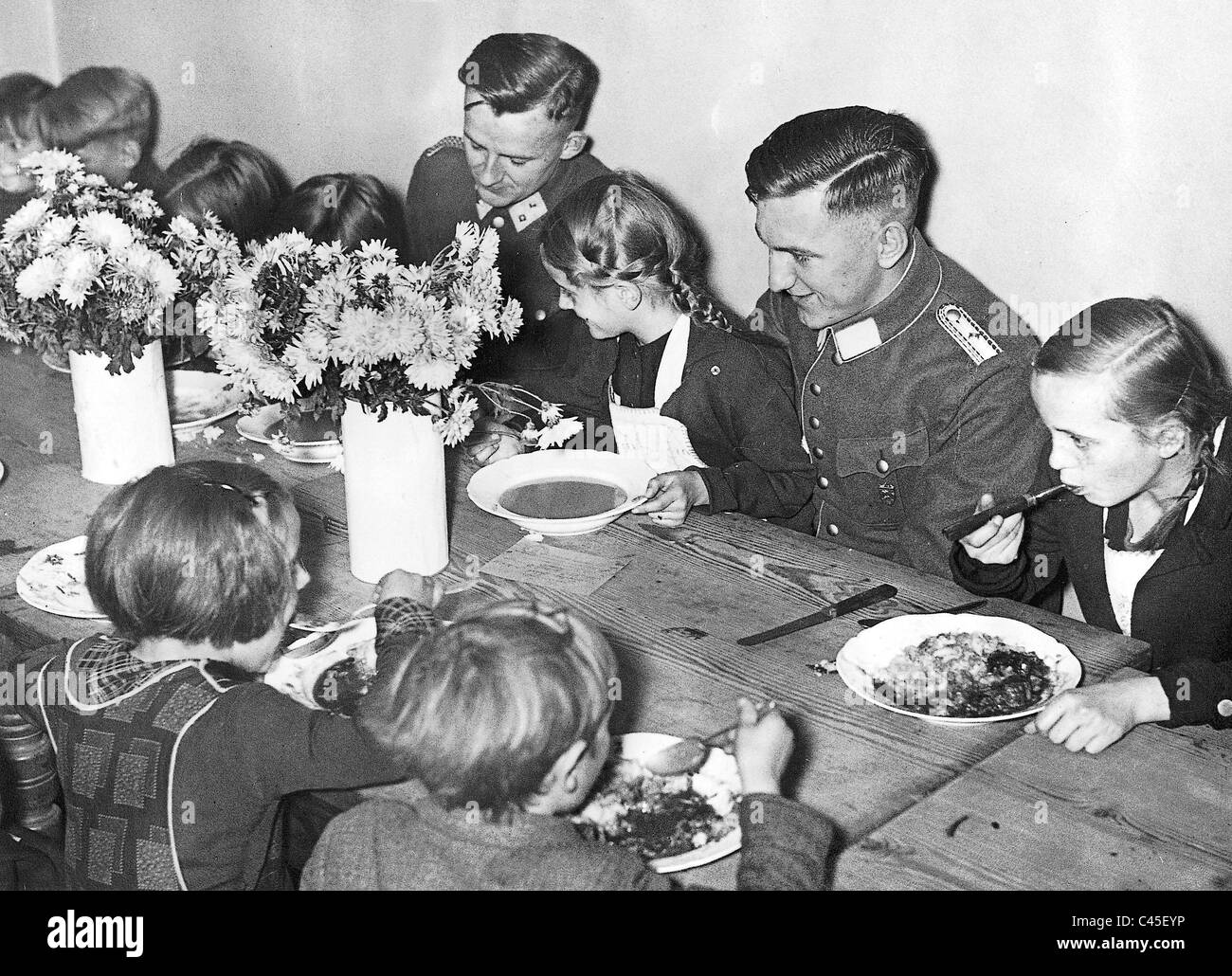 Soldaten im Dienste des Winter Reliefs Essen mit Kindern, Berlin 1935 Stockfoto