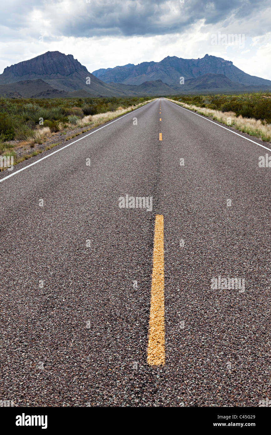 Offene Straße nach Bergen mit dunklen Wolken Big Bend Nationalpark Texas USA Stockfoto