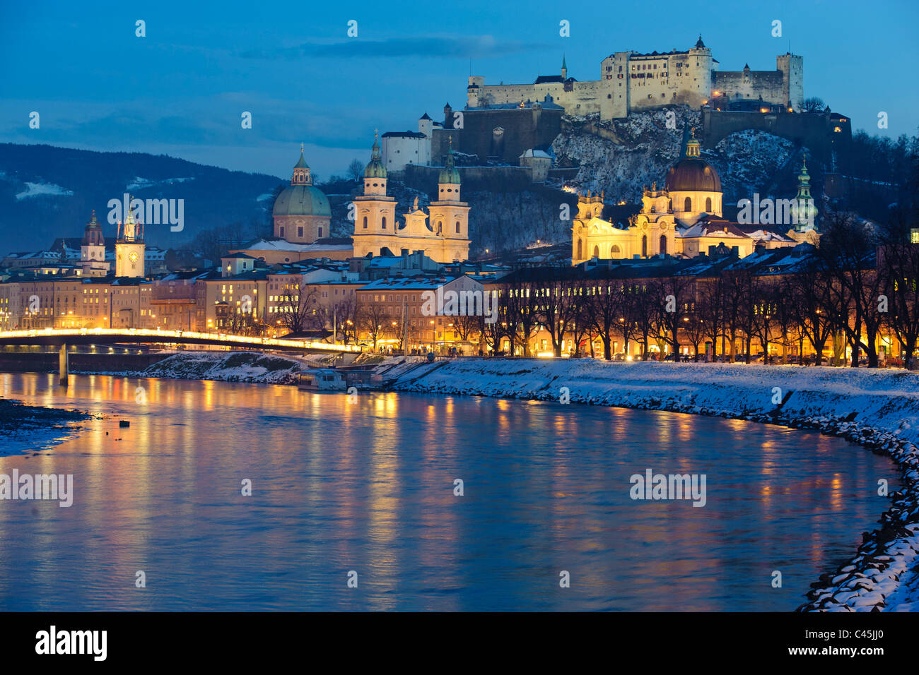 Panoramaansicht der mittelalterlichen Stadt Salzburg in Österreich mit Burg und Fluss Salzach in der Nacht im winter Stockfoto