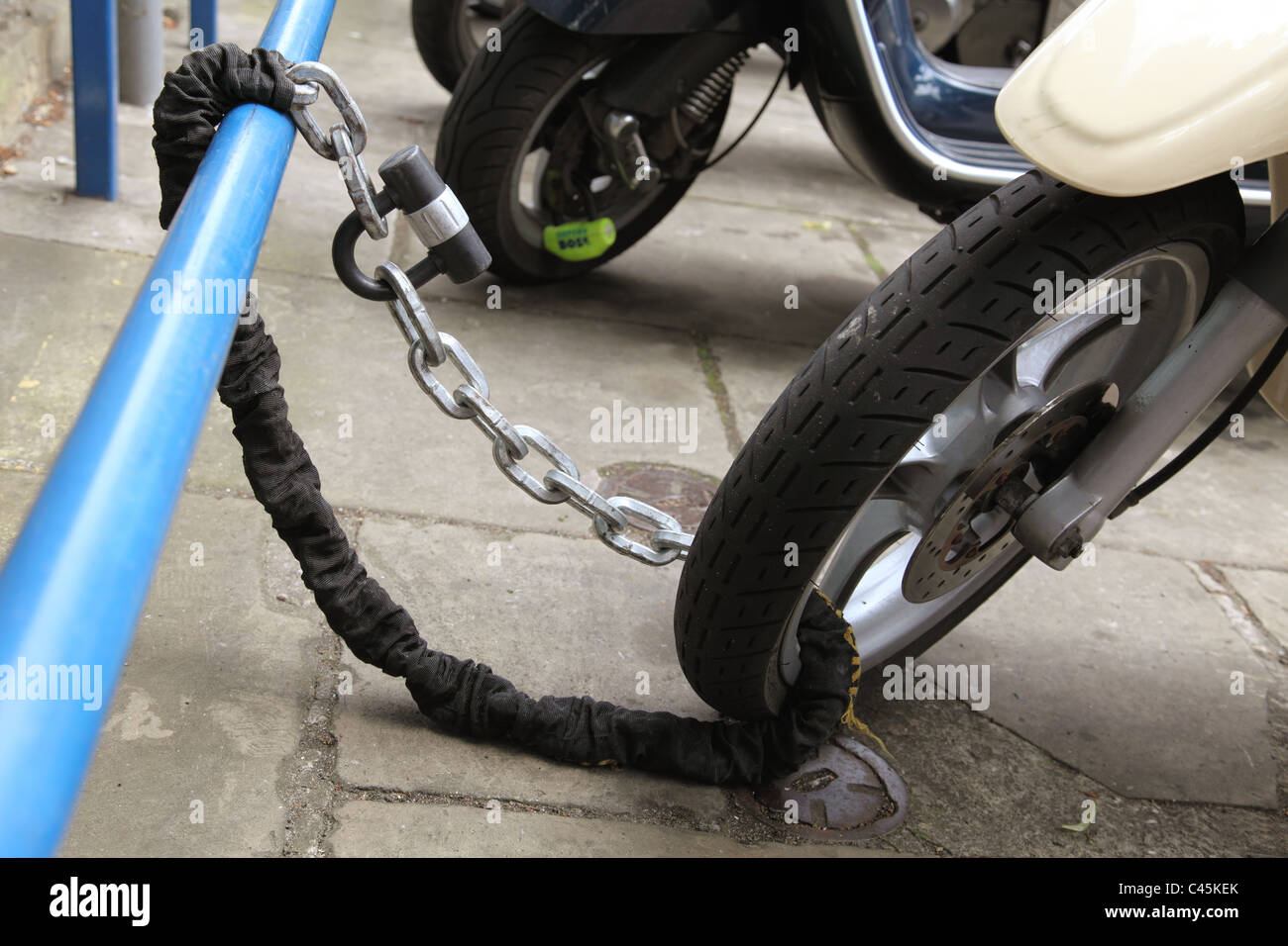 Einem geparkten Roller sicher angekettet in einer Straße U.K. Stockfoto