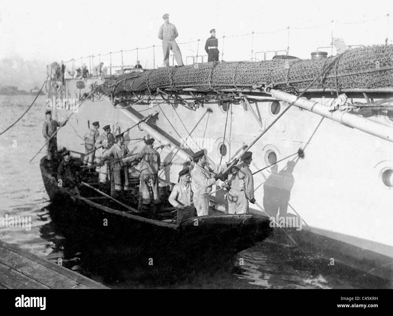 Crew reinigen die Außenwände von einem Kriegsschiff, 1916 Stockfoto