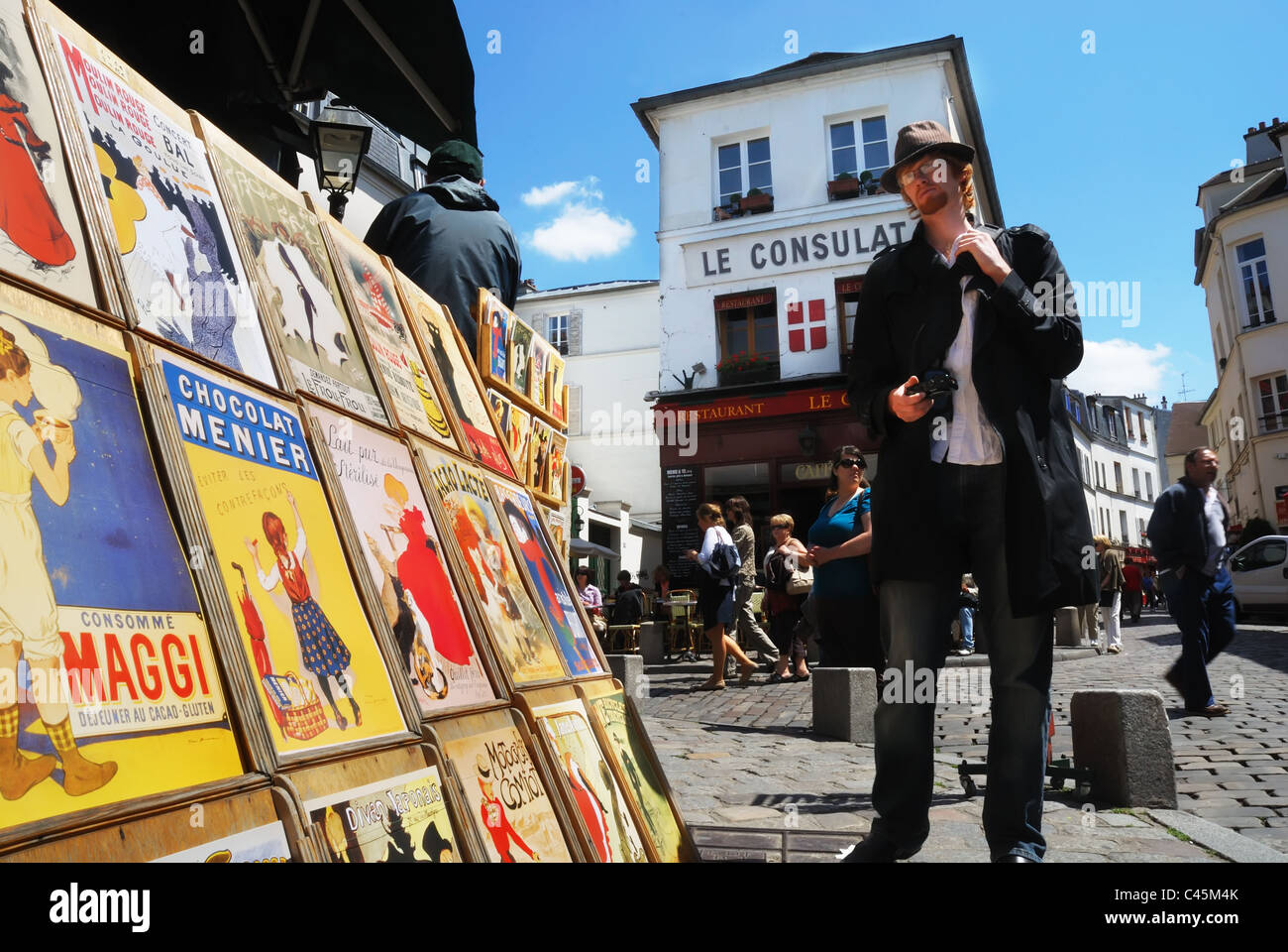 Ein Mann betrachtet man Jugendstil Poster in einem Rack in den Straßen von Montmartre, Paris Stockfoto