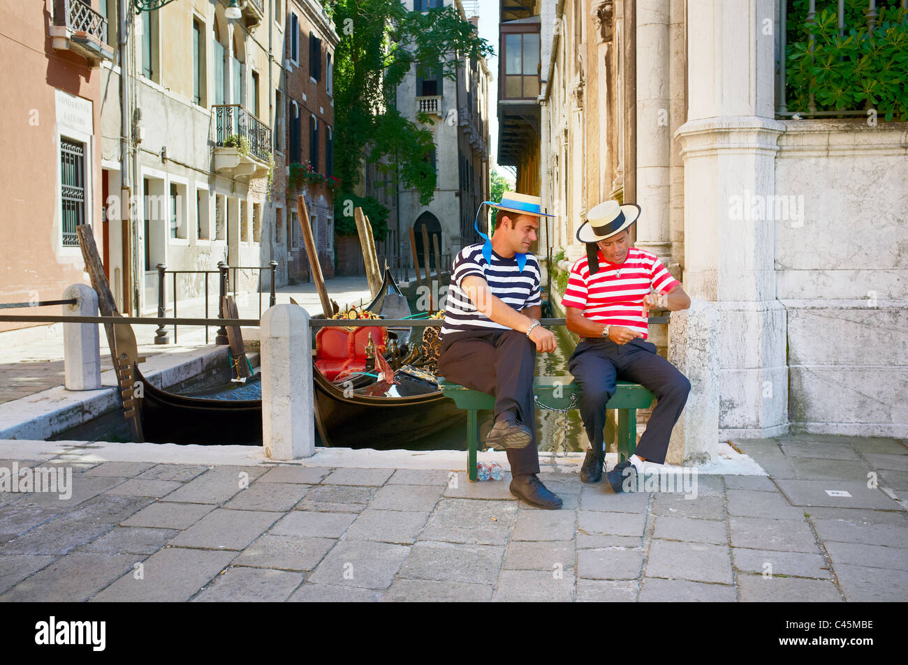 Zwei Gondolieri sitzen und plaudern. Venedig, Veneto, Italien. Stockfoto