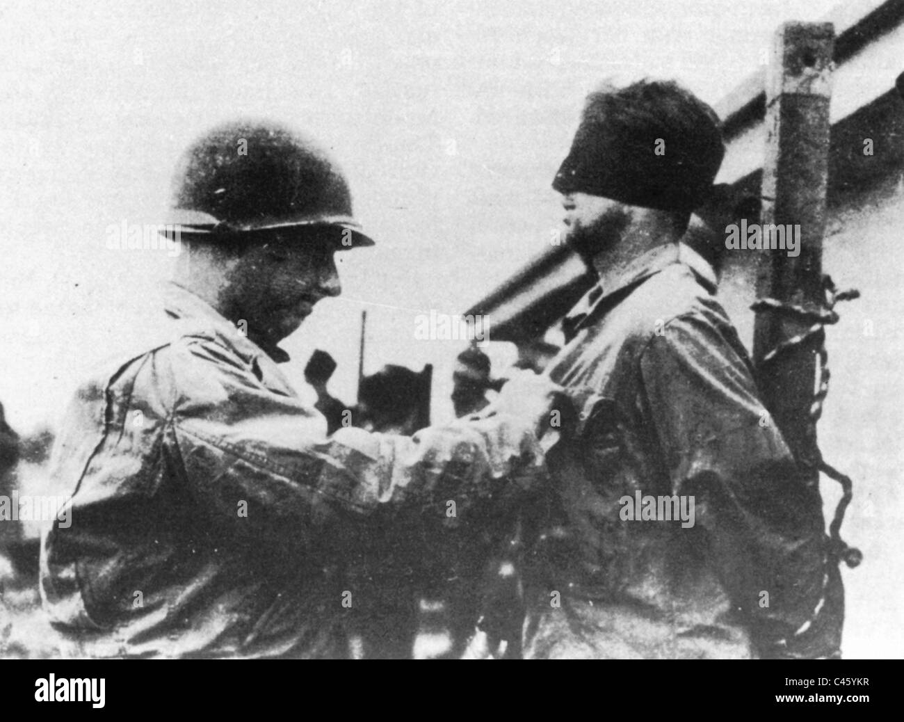 Ein amerikanischer Soldat Augenbinden ein Soldat von Skorzenys Befehl, 1944 Stockfoto