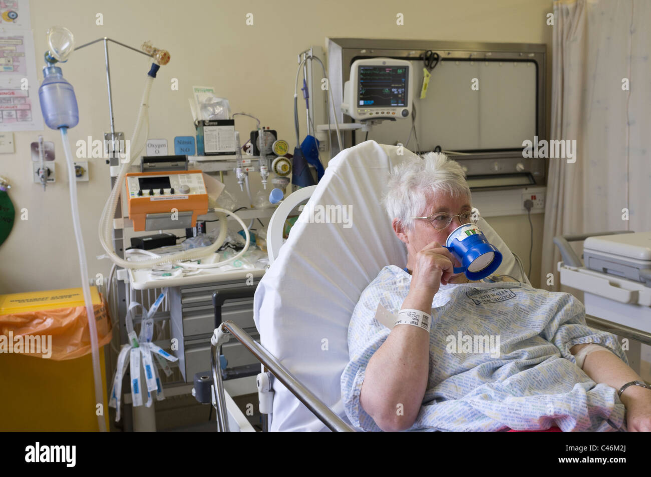 Ältere Frau Patienten Tee trinken Erholung in Reanimation Einheit in der Notfallstation eines Krankenhauses nach einem Herzinfarkt. Wales, Großbritannien. Stockfoto