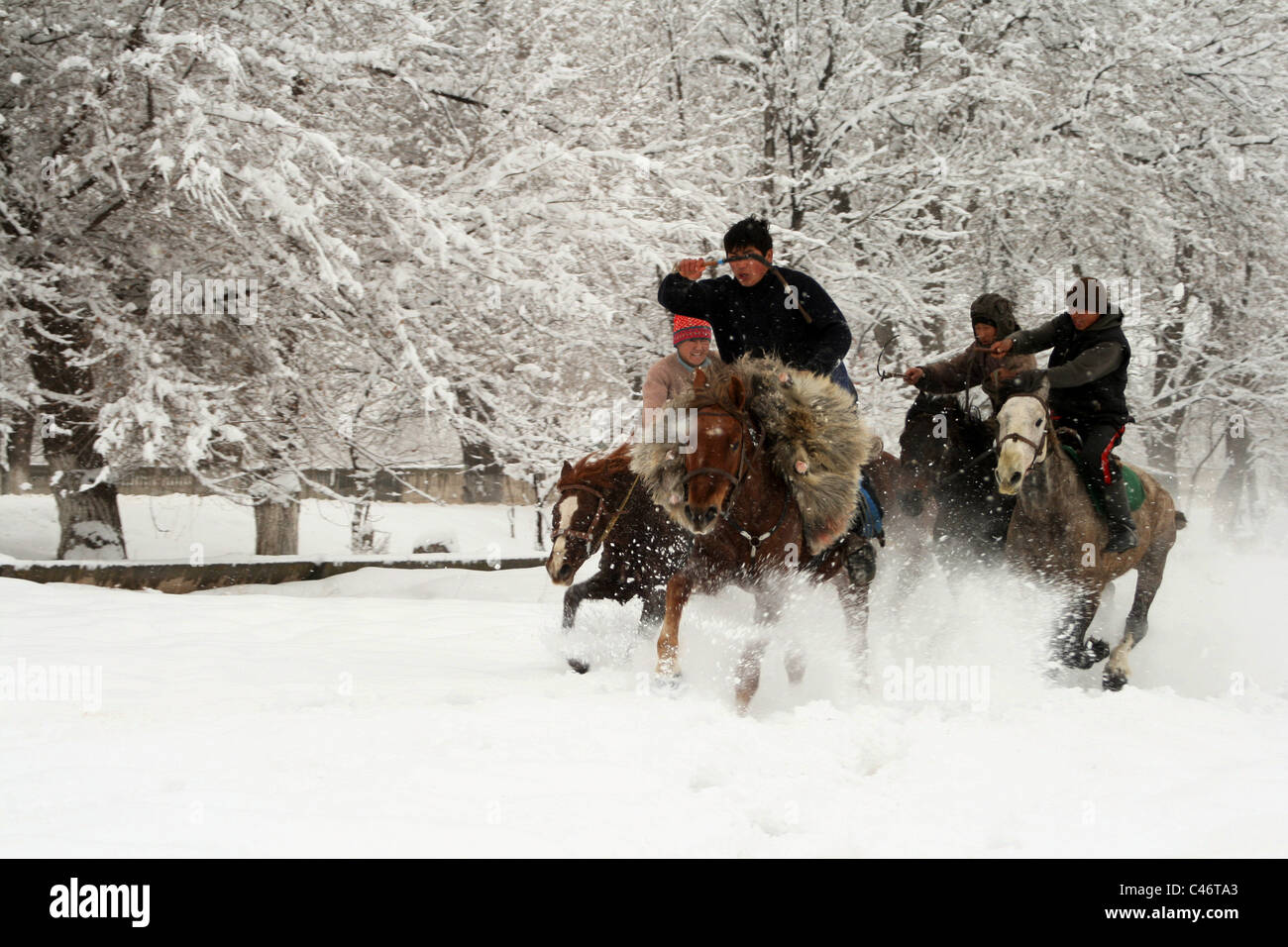 Laufende Reiter, Ulak Spieler auf dem Schnee, Kirgisistan Stockfoto