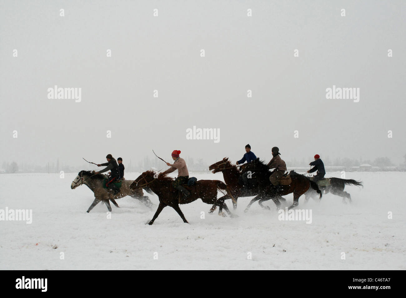 Laufende Reiter auf dem Schnee, Kirgisistan Stockfoto