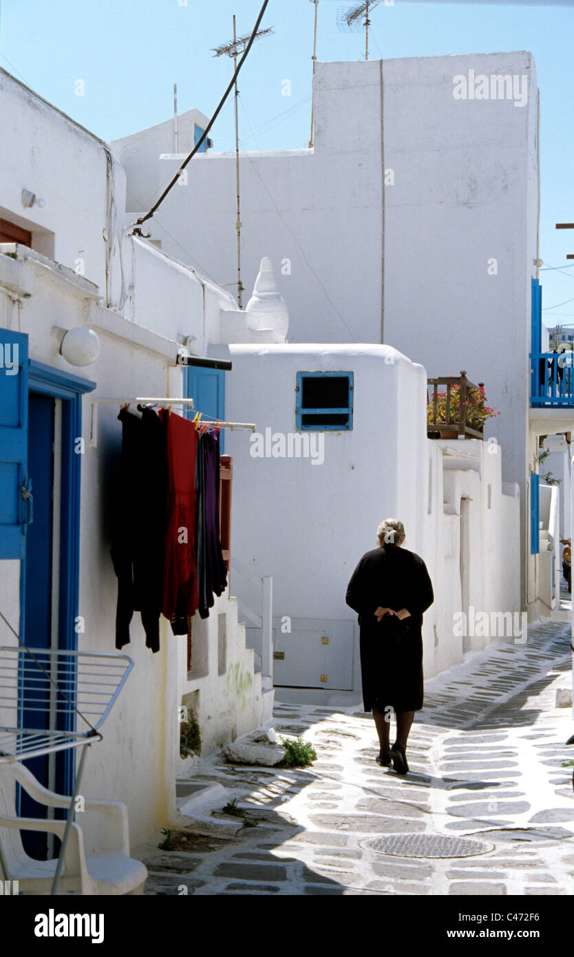 Alte Griechin Spaziergänge auf gepflasterten Straßen der alten Stadt Mykonos Griechenland Stockfoto