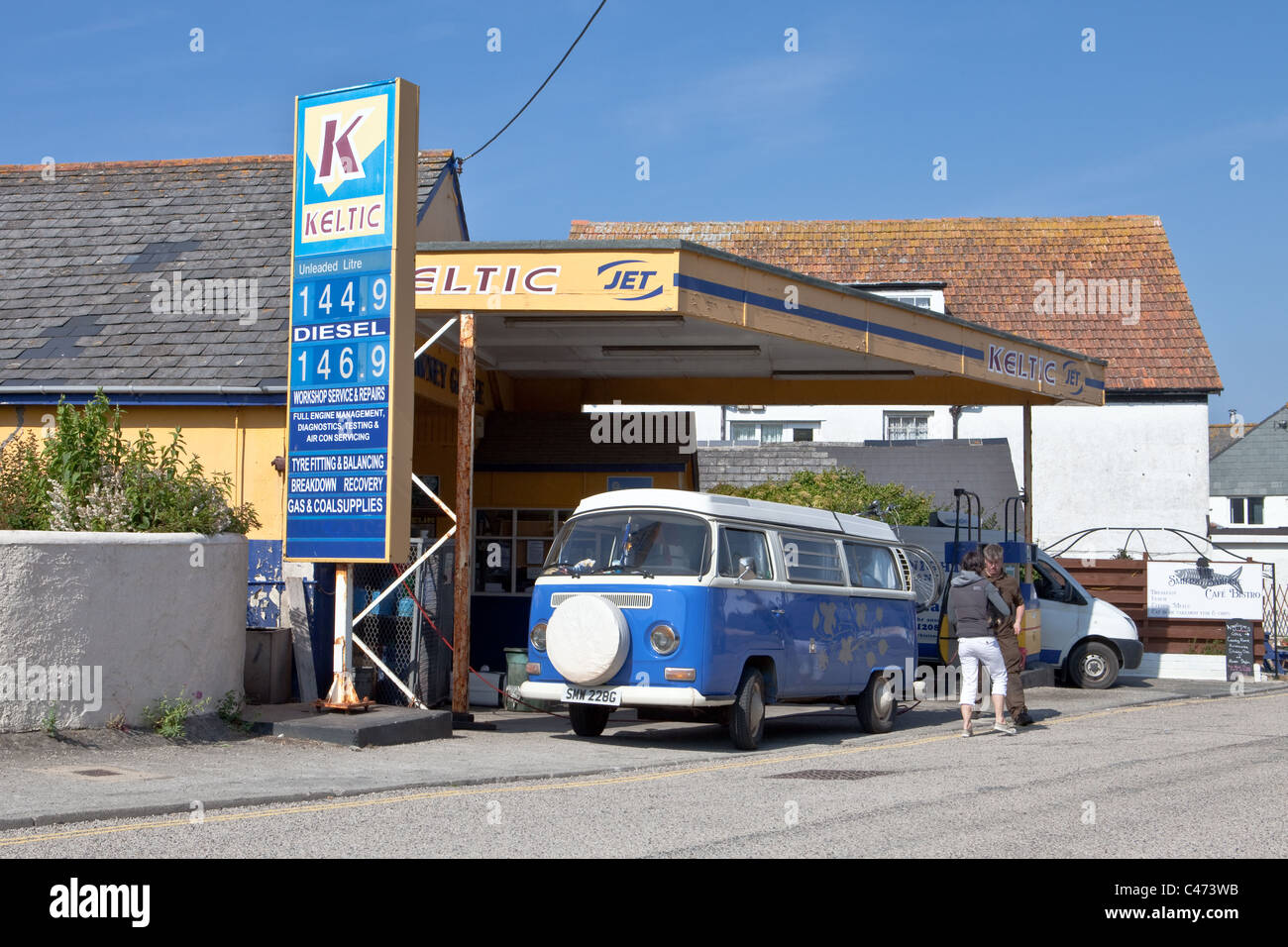 Blauen VW Camper van in einer kleinen Tankstelle in Port Isaac, Cornwall Stockfoto