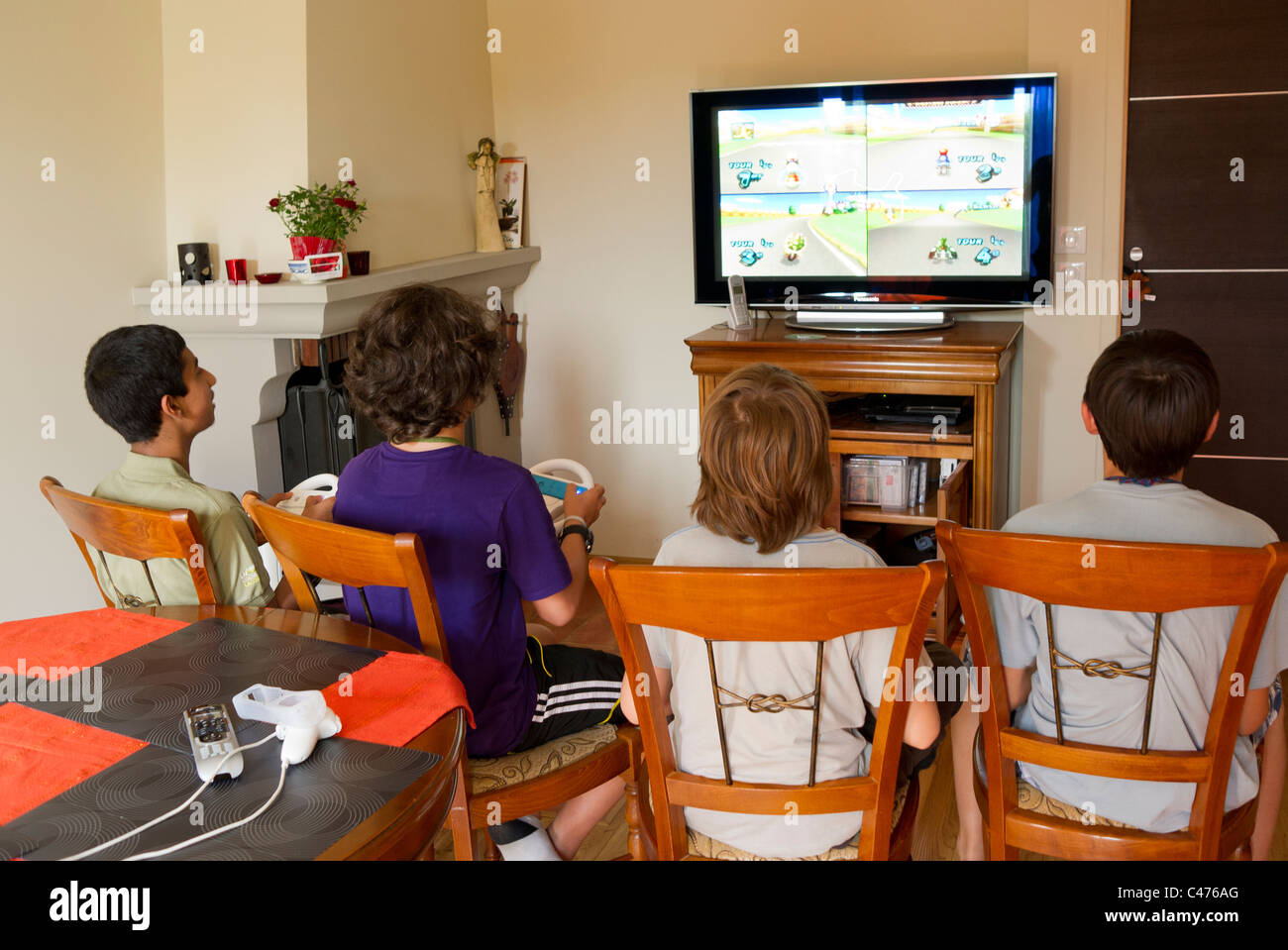 4 junge Teenages spielen Wii Nintendo Konsolen-Spiele Stockfoto