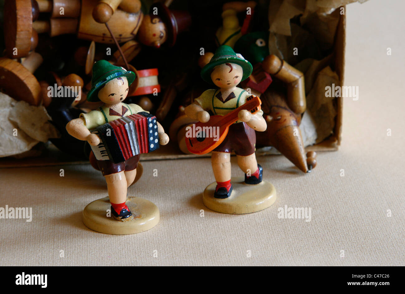 Zwei kleine Holz geschnitzten Figuren der Dregeno Seiffen eG wie Musiker mit anderen Puppen, Deutschland vor einer Box angezeigt. Stockfoto