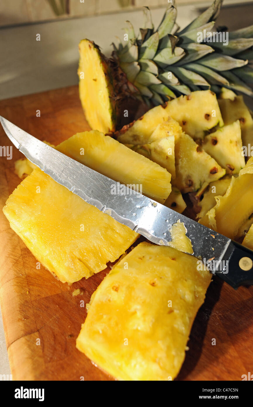 Frische Ananas Frucht in Scheiben geschnitten mit Messer mit Rand geriffelt Stockfoto