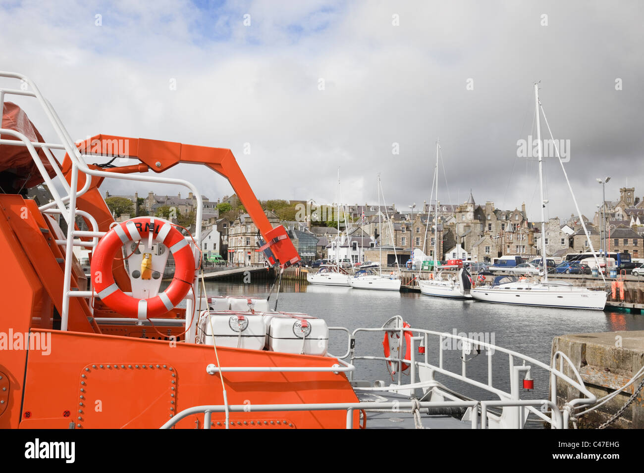 Lerwick, Shetland Islands, Schottland, Großbritannien. RNLI-Rettungsboot in den kleinen Bootshafen mit der alten städtischen Uferpromenade über angedockt Stockfoto