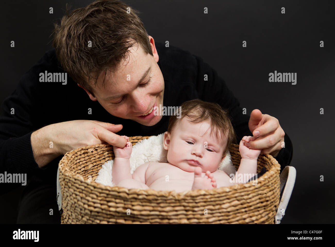 Babymädchen in einen Korb mit ihrem Vater Stockfoto