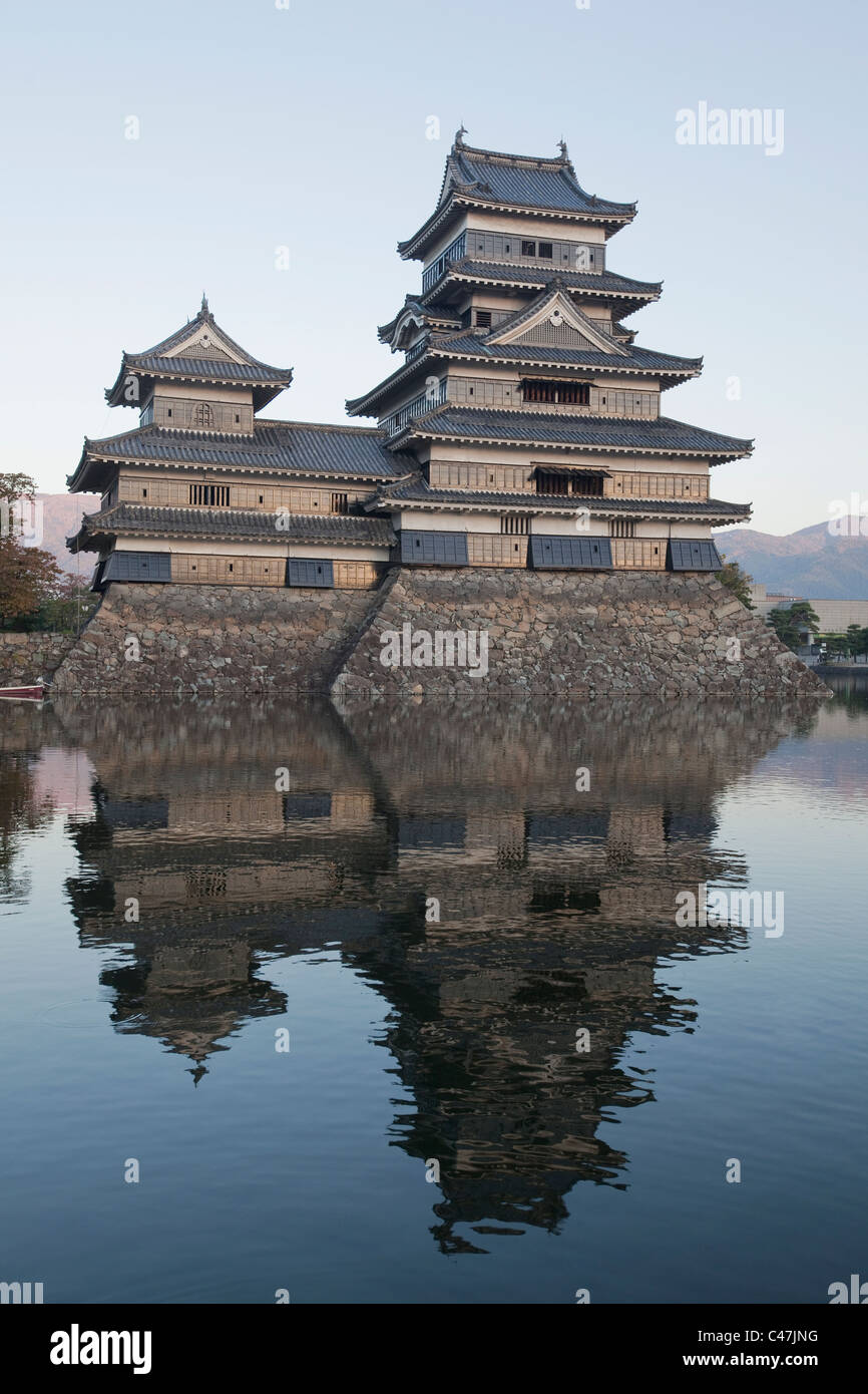 Matsumoto Castle und ihre Reflexion im Graben bei Dämmerung, Matsumoto, Nagano, Japan. Stockfoto