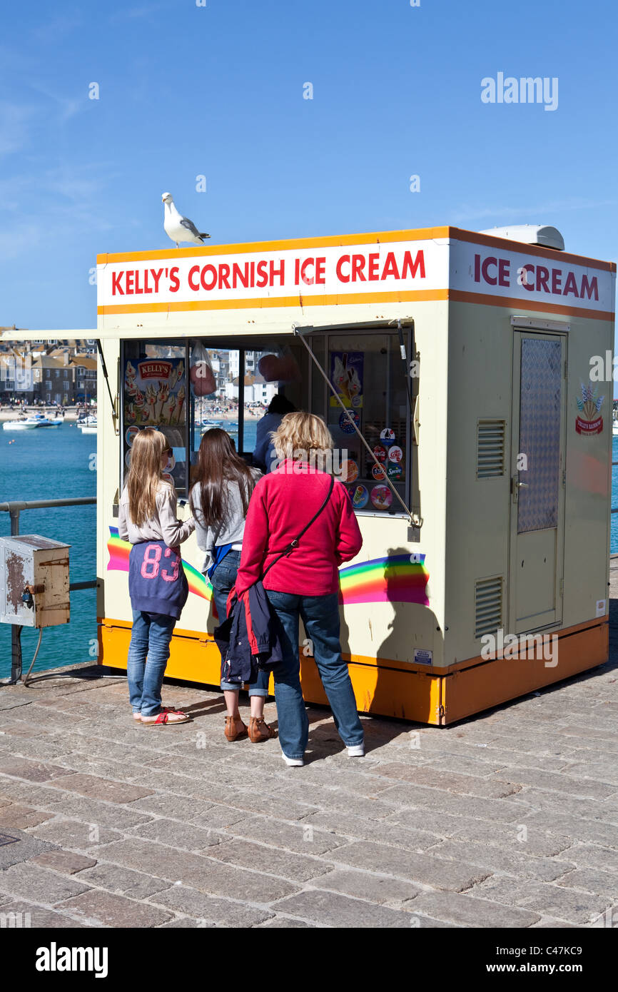 Besucher kaufen Eis an einem Kiosk auf der Strandpromenade von St. Ives, Cornwall Stockfoto